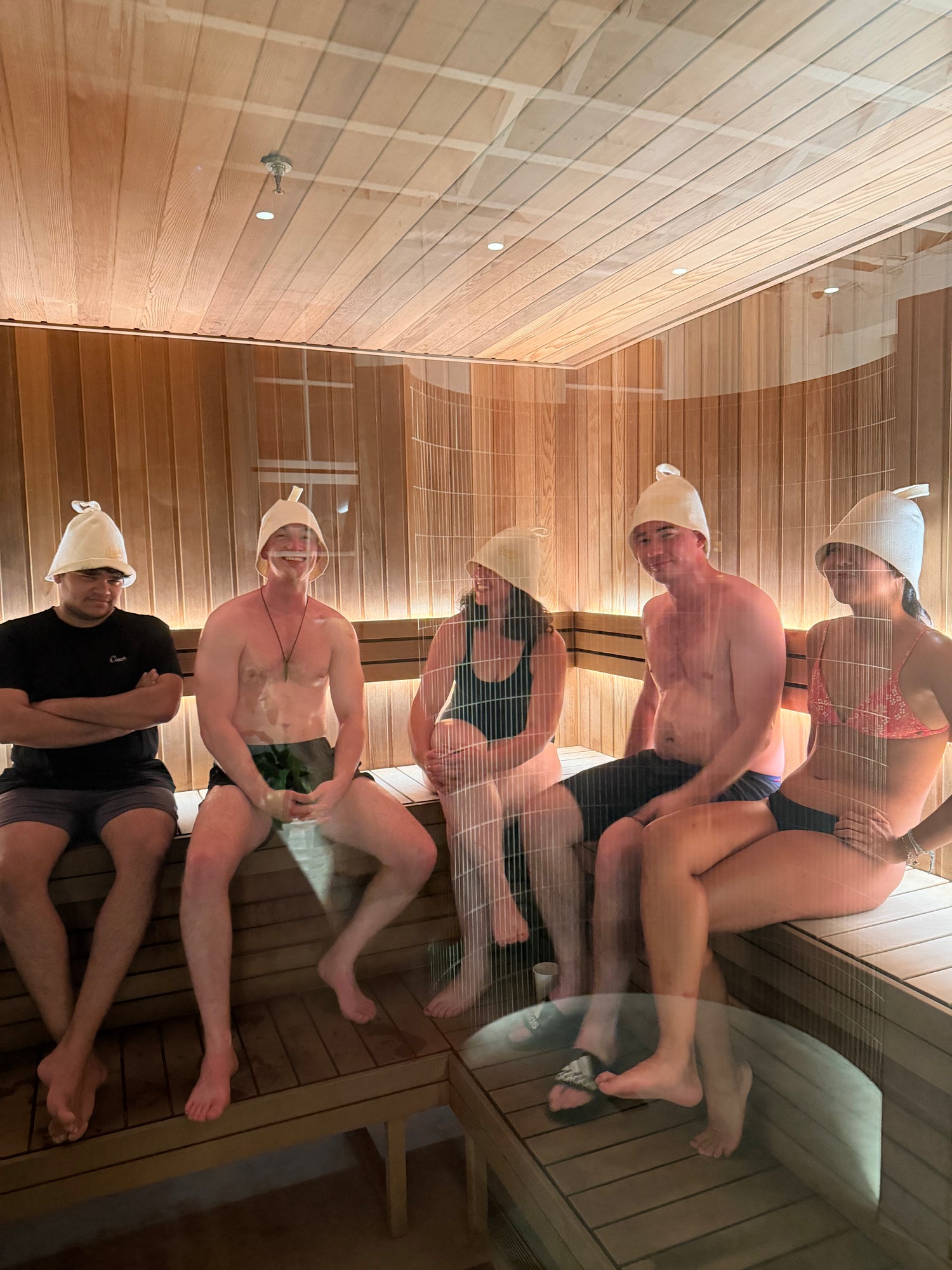 People sitting in a sauna with wooden interior